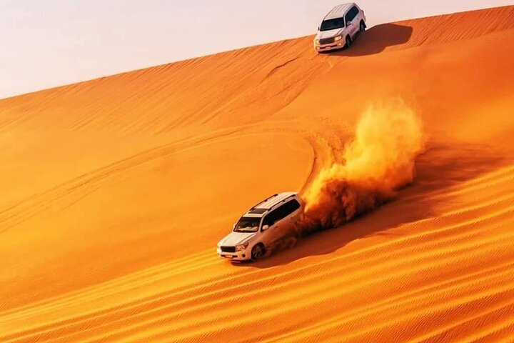 Experience the vast Red Sand Dunes of Dubai where the excitement of desert driving meets stunning landscapes creating unforgettable memories under the golden sun. Capture the essence of adventure.